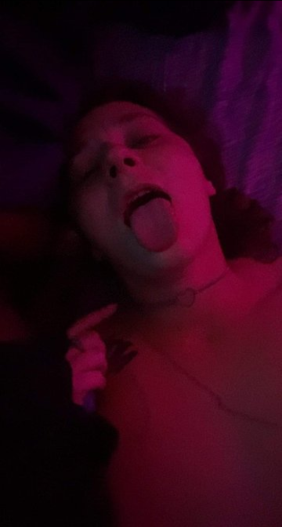 Submissive woman sticks out her tongue